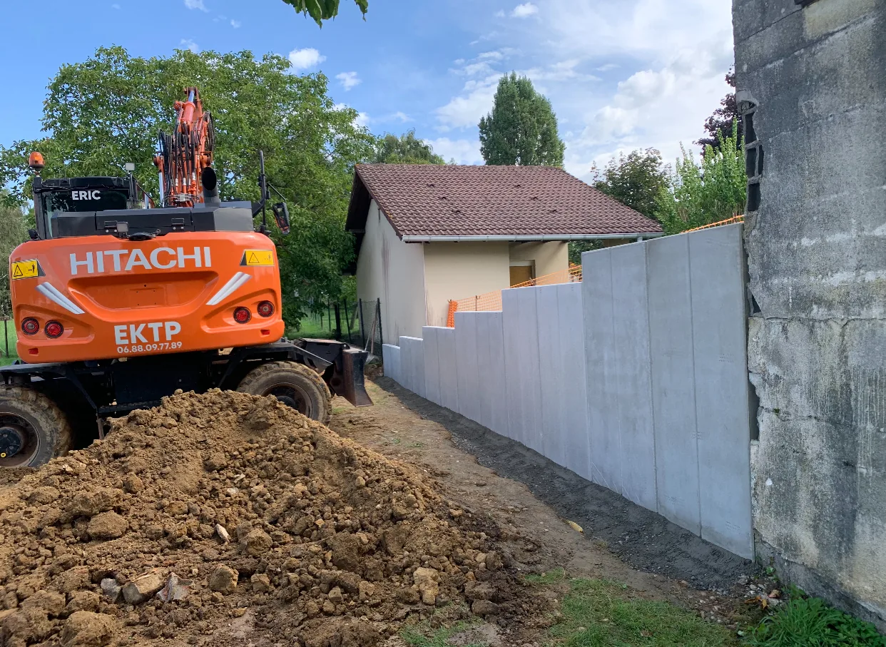 Pose d'un mur en L en béton préfabriqué par EKTP avec pelle Hitachi en Moselle